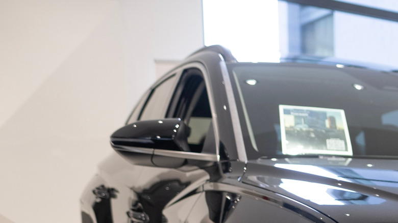 A black 2023 Hyundai Tucson Plug-in Hybrid SUV on display in a dealership showroom