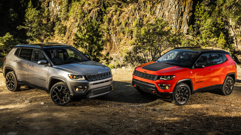 Pair of 2021 Jeep Compass models parked off-road by some trees
