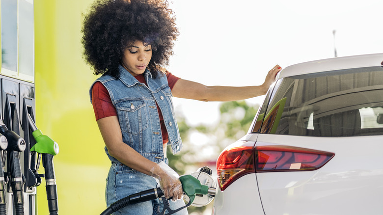 Woman filling her car with gasoline.