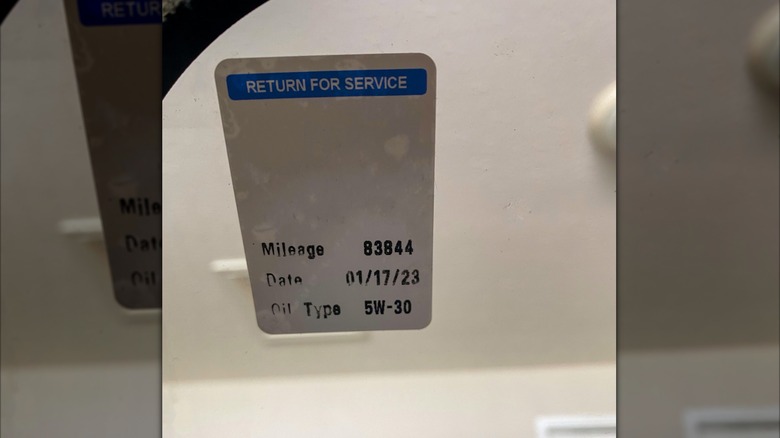 Oil change reminder sticker on a windshield.