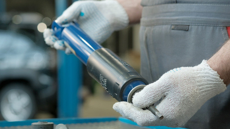 Suspension shock absorber in the hands of an auto mechanic