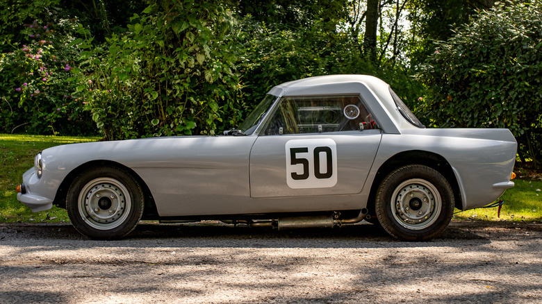 A side view of a light-colored GSM Delta with a 50 on the door parked outside.