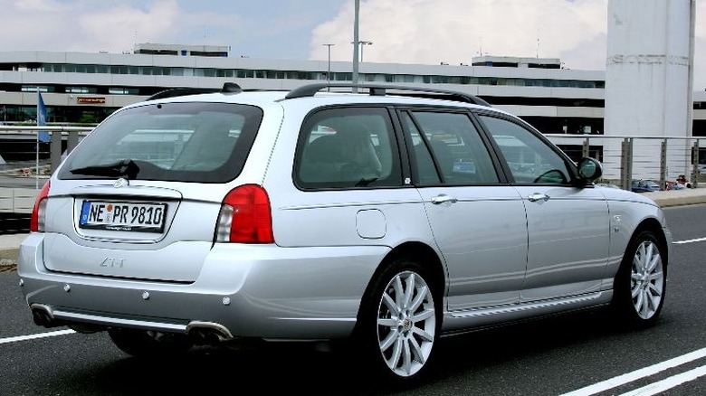 A rear side view of a silver MG ZT-T 260 wagon driving on the highway.