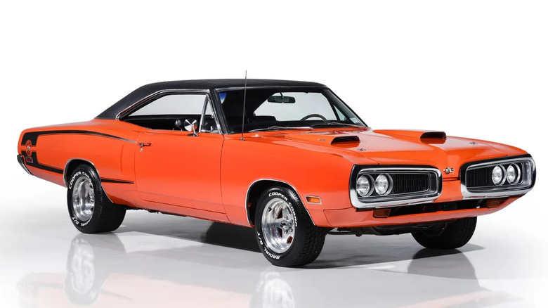 An orange dodge Super Bee with a black roof against a white background.