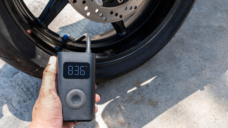 A portable tire inflator is applied to a motorcycle tire.