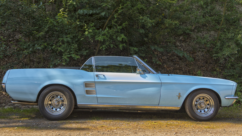 A light blue 1967 Ford Mustang convertible parked outside