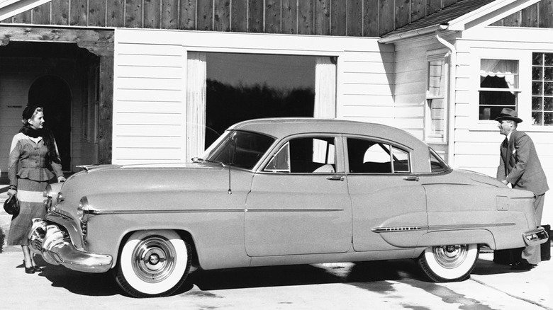 1950 Oldsmobile 98 four-door with a husband and wife in black and white