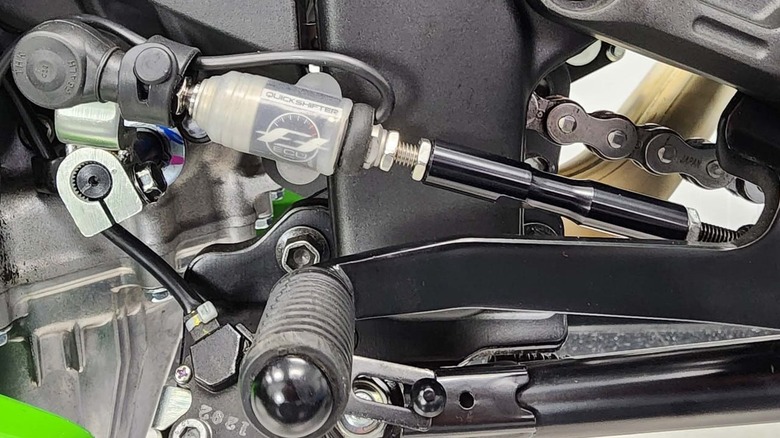 A motorcycle quickshifter is viewed up close.