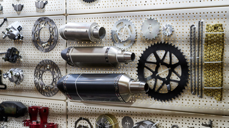 Motorcycle parts are displayed on a pegboard wall.