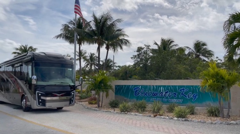 An RV parked beside the Bluewater Key logo on a short stone wall