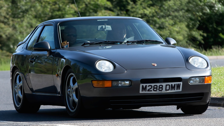 Dark gray Porsche 968 coupe driving on the road