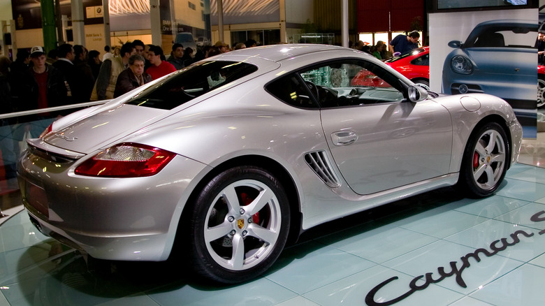 Silver Porsche Cayman S on display at an indoor car show