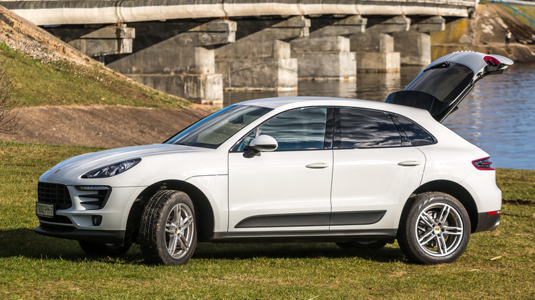 A white Porsche Macan with the rear hatch open parked outside
