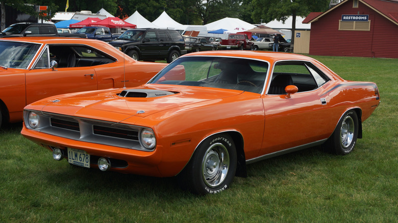 Orange 1970 Plymouth Barracuda coupe left front three-quarter view parked at outdoor car show