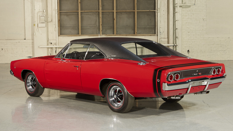 Red 1968 Dodge Charger R/T coupe left rear three-quarter view parked in an industrial area