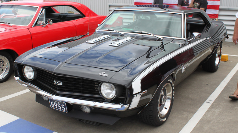 Black 1969 Chevrolet Camaro sports coupe left front three-quarter view parked at outdoor car show