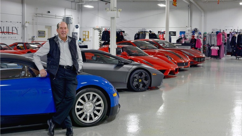 Ken Lingenfelter beside multiple supercars