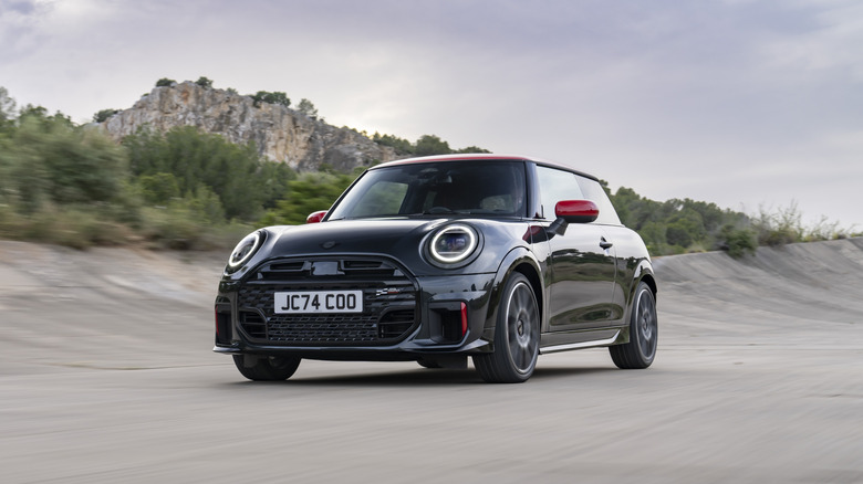 A gray Porsche Cayenne takes a turn in the city.