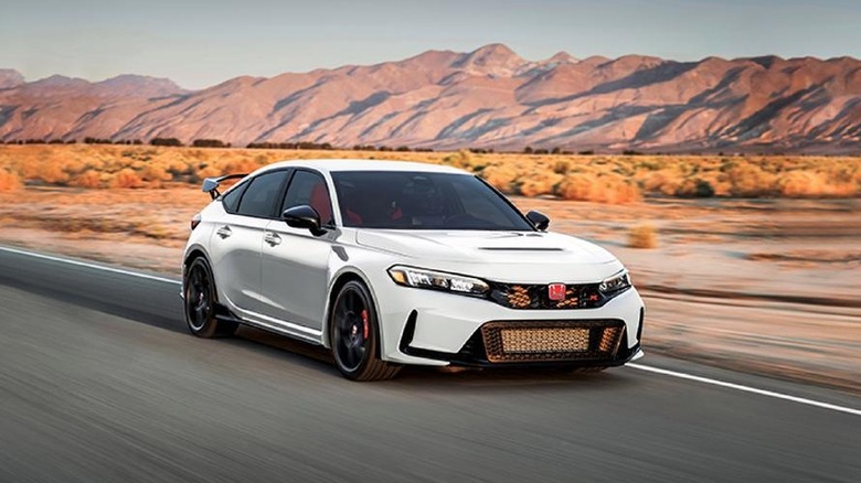 A white Honda Civic Type R drives through the desert.