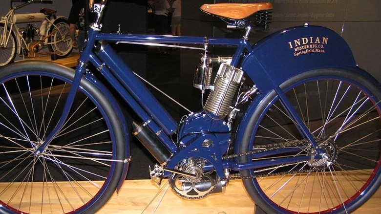 A blue early-1900s Indian Camelback motorcycle on display at a museum.