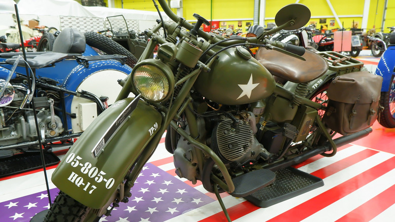 A military-green Indian 841 army motorcycle on display at a vintage exhibition.