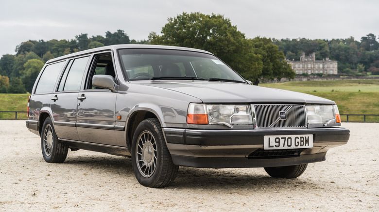 A gray Volvo 960 sitting parked on an estate.