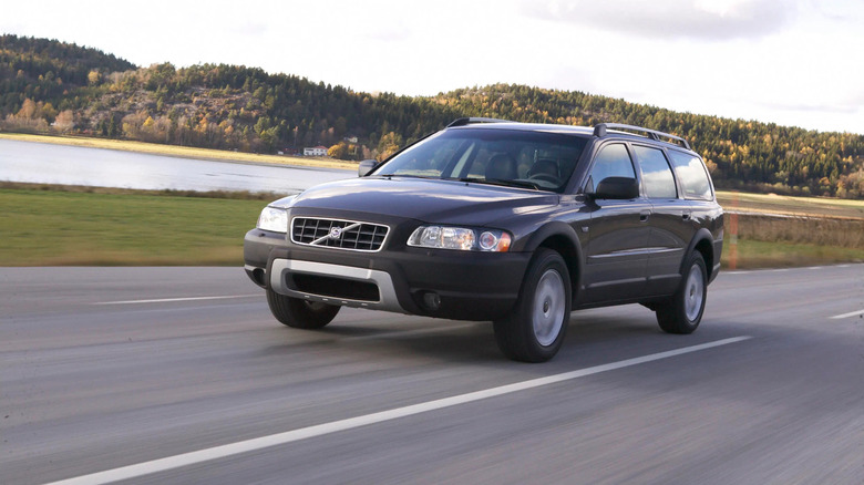 A dark-colored Volvo XC70 driving down the road.