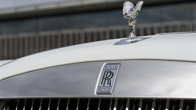 A silver Rolls-Royce hood ornament sticks out above a silver grill and inlaid 
