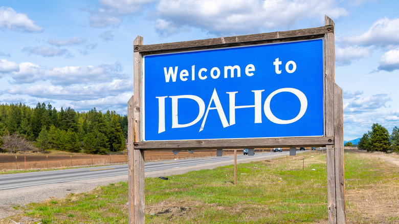 A welcome sign near a road, it says "Welcome to Idaho"