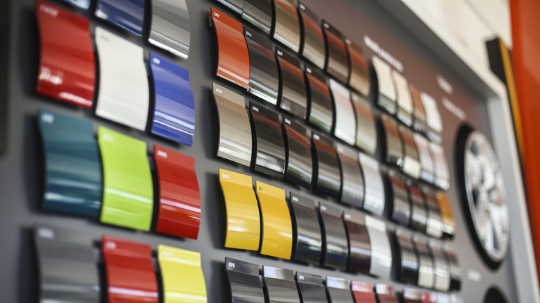 A wall of colorful paint samples at a car dealership.