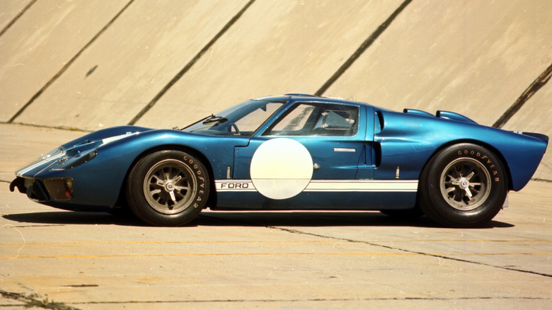 A side profile of a blue 1966 Ford GT40 Mk II with white racing stripes and white number roundels.