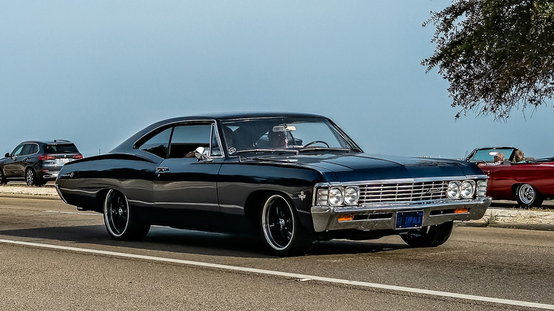 Black Chevy Impala on the road with blue skies