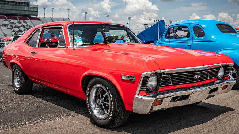 Bright red Chevy Nova with SS badging at a race track
