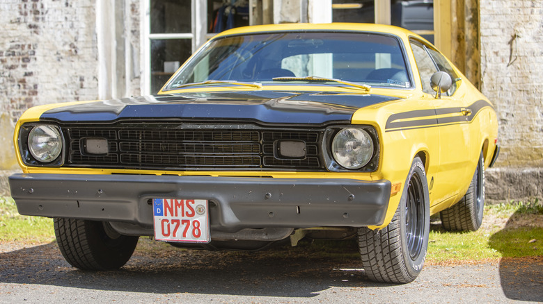 Yellow Plymouth Duster with black accents parked outside