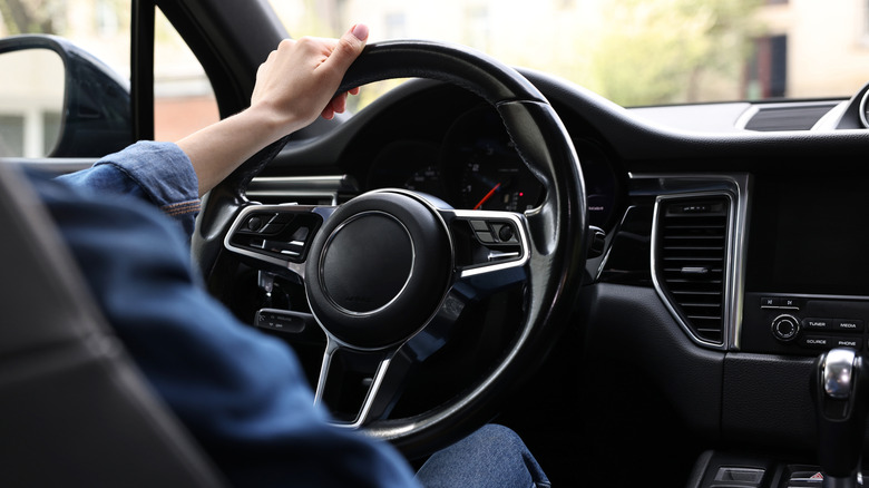 Person holds unbranded steering wheel.