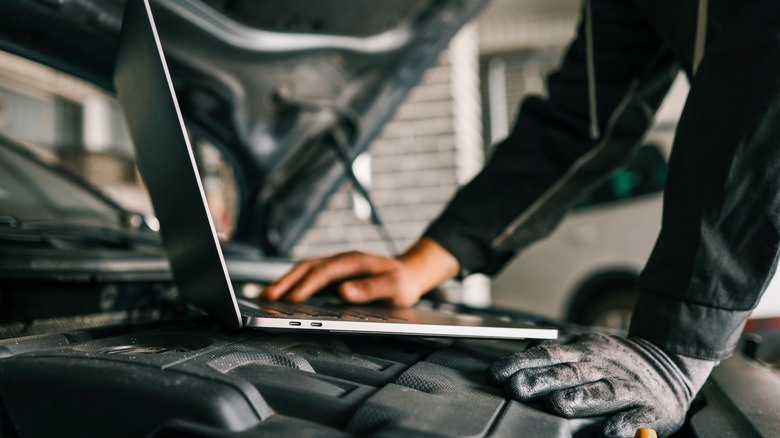 Mechanic using computer to tune engine.