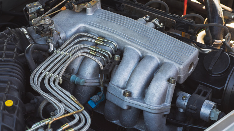Aluminum intake manifold fed with braided lines.