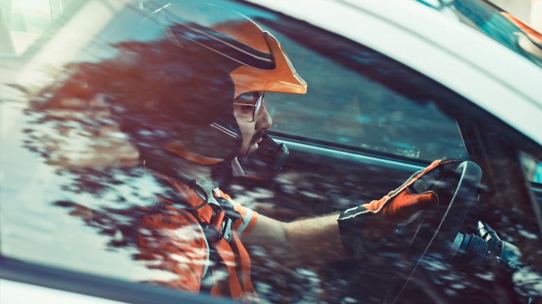 Racecar driver looks intensely up ahead at the start line.