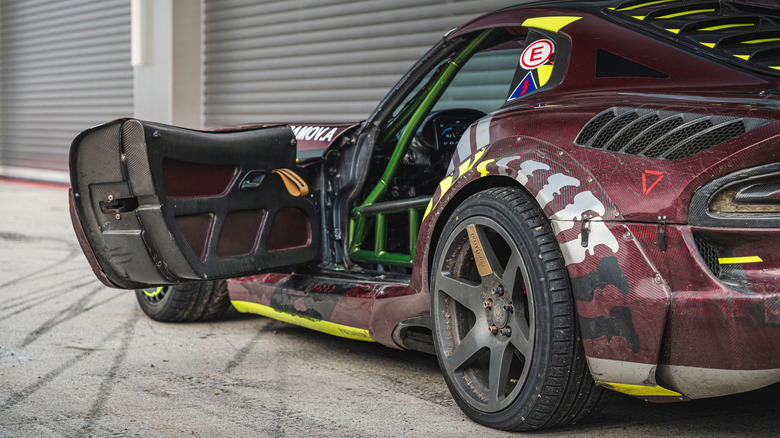 Maroon racecar with carbon fiber door panels.