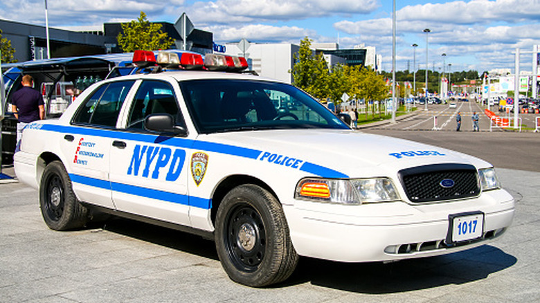 Front 3/4 view of a Ford Crown Victoria Police Interceptor of the NYPD parked on a city street.