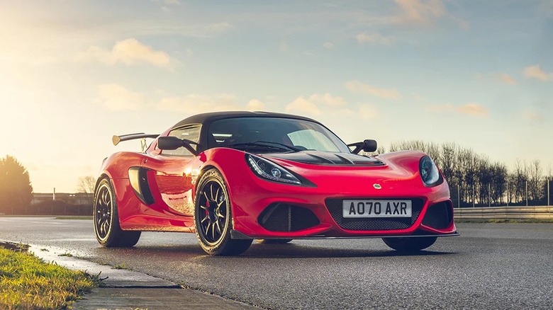 A red Lotus Exige Sport 420 Final Edition parked on a race track at sunset, showcasing its aggressive front aero and wide stance.