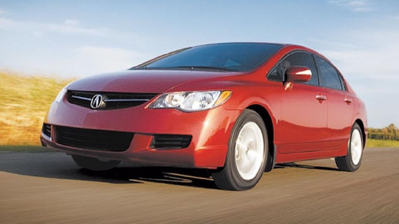 A red Acura CSX drives on the road.
