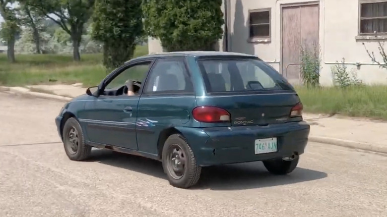A Pontiac Firefly drives away.