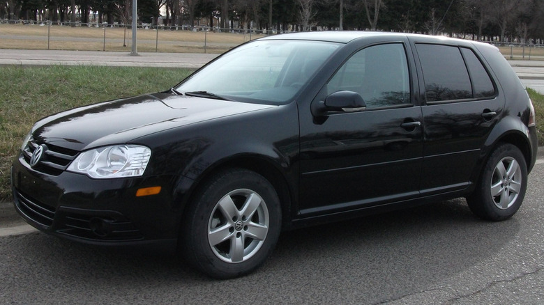 A black Volkswagen City Golf parks on the street.