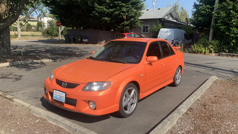 Orange 2003 Mazdaspeed Protege sits in parking space.