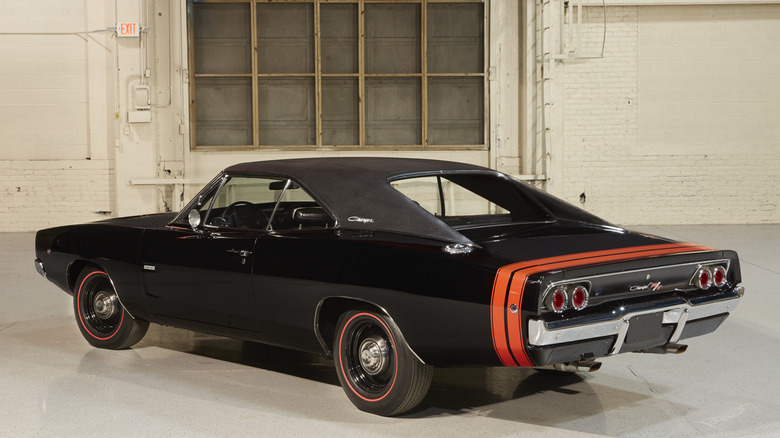 Black 1968 Dodge Charger R/T coupe left rear three-quarter view parked in an industrial area