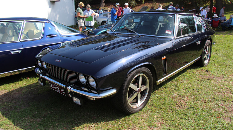 Dark blue Jensen Interceptor Mark III sports coupe left front three-quarter view parked next to another Jensen Interceptor at an outdoor car show