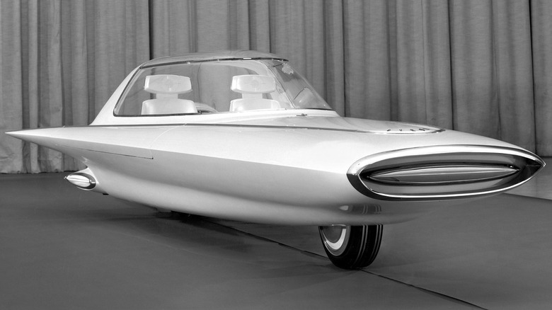 A black-and-white photo of the 1961 Ford Gyron concept car, showing its two-wheeled gyroscopically balanced spindle body, wide horizontal front grille pod, and Jet Age bubble canopy.