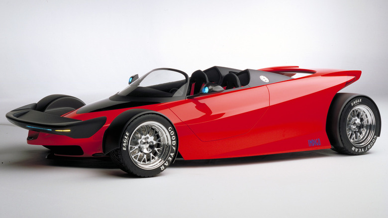 The vibrant red 1996 Ford IndiGo roadster concept, displaying its IndyCar-inspired open-wheel layout, integrated front aerodynamic wing, and low roadster cockpit.