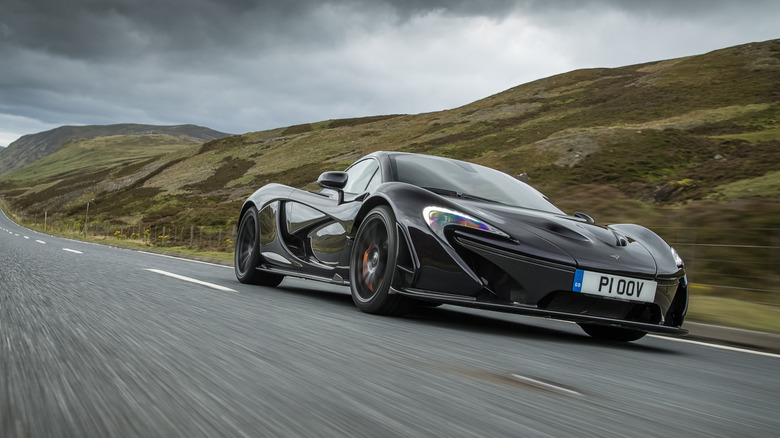2013 McLaren P1 driving at speed on public road front 3/4 view